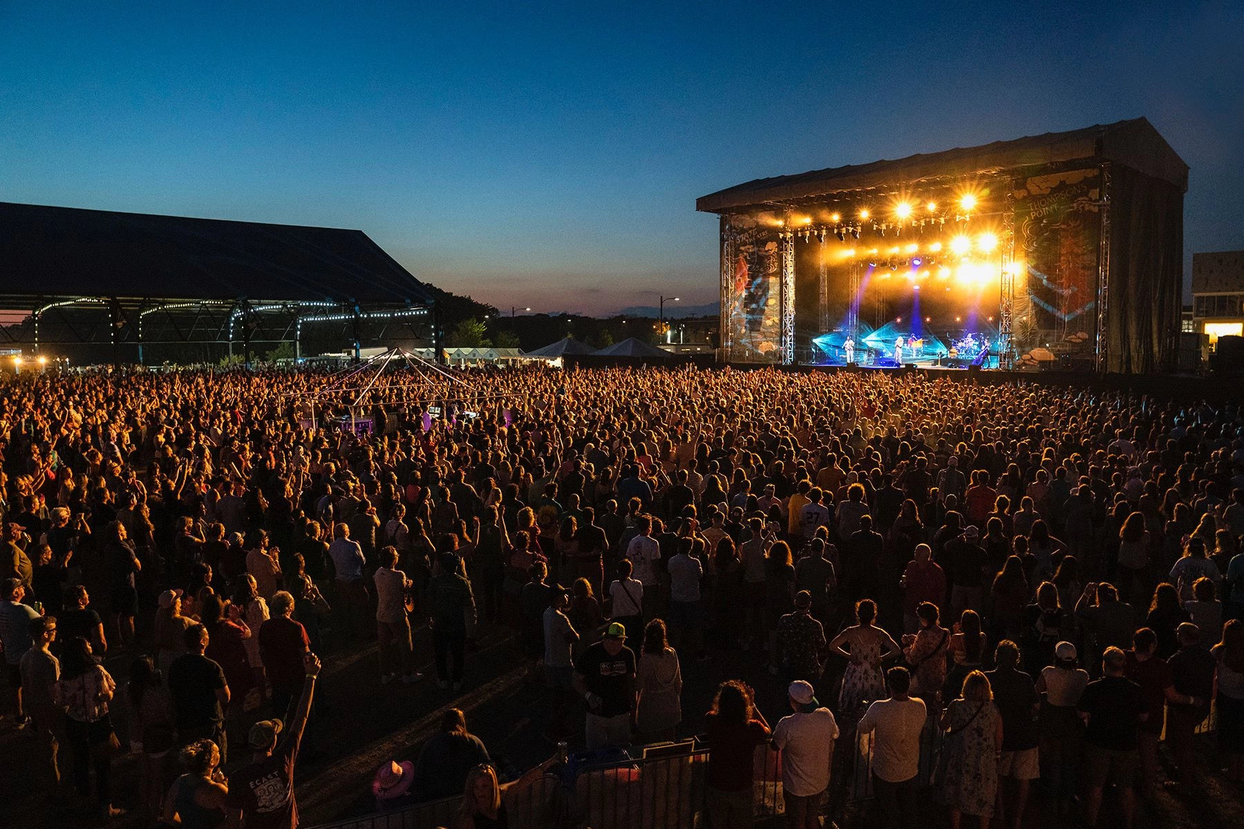 A massive festival audience facing the live stage